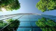 © Sergey - Looking up at a modern glass building framed by lush green trees against a clear blue sky, symbolizing eco-friendly architecture.