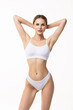 © F8  \ Suport Ukraine - Smiling sporty woman in white underwear posing on studio background. Female beauty, sport, spa concept