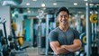 © gn8 - Fit and Smiling Asian Male Fitness Trainer in a Modern Gym Setting, Standing with Confidence, Promoting Health and Wellbeing