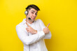 © luismolinero - Telemarketer caucasian man working with a headset isolated on yellow background pointing to the laterals having doubts