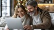 © Pixel Mind - Couple smiles while browsing online together during Christmas season