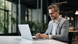© Наталья Сивак - Smiling Businessman Working on Laptop in Modern Office