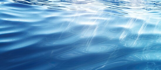 Poster - A nature background showcasing a sunlit blue rippled water surface texture with light reflections Perfect for beach vacations spa beauty care or as a copy space image