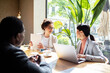 © Marko Geber - Business meeting in a cafe with diverse professionals
