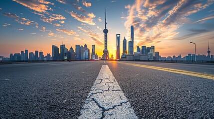 Photograph of an empty asphalt road and city skyline with buildings at sunset in Shanghai.