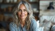 © svastix - A closeup image capturing a mature woman with a friendly smile and naturally gray hair in a cozy indoor setting with soft focus background