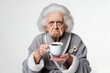© Anna - grumpy old woman in bathrobe holding cup of coffee Isolated on white background