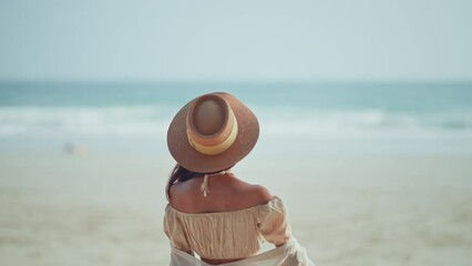 Wall Mural - Happy Young Asian woman with straw hat walking on tropical beach, Carefree female enjoying breeze with sea in background. Travel vacation, summer outdoor pleasure.