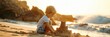 © firax - Young boy builds sandcastle on sunny beach at sunset. Copy space