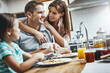 © Reese Coop/peopleimages.com - Hug, breakfast pancakes and happy family with children, mother and father, bonding and parenting embrace. Morning food, cooking and hungry woman, man and daughter in home kitchen eating meal