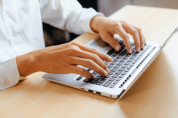 Wall Mural - businessman hand typing on computer keyboard of a laptop computer in office. business and finance co