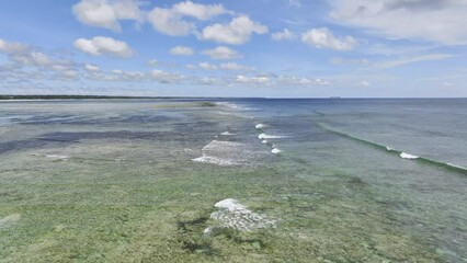 Wall Mural - Aerial view of a coral reef at low tide, waves, sandbank in ocean, white sand, seaweed farms, blue sea at sunny summer day in Zanzibar. Top drone view of sand spit, clear water, sky, clouds. Tropical