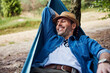 © baranq - Happy adult man relaxing in hammock
