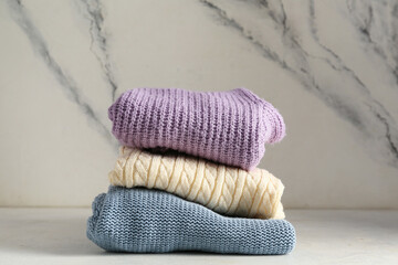 Wall Mural - Stack of different stylish sweaters on light background