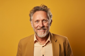 Poster - Portrait of a happy senior man looking at camera over yellow background