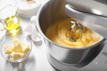 Making dough in bowl of stand mixer on white table, closeup