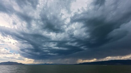 Wall Mural - Storm clouds moving over Utah Lake in time lapse during summer monsoon.