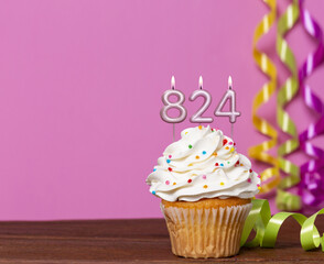 Birthday Cupcake With Candles Lit Forming The Number 824