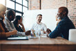 © NonVig/peopleimages.com - Man, manager and business meeting in boardroom for financial growth with laughing at table. People, company and workshop with coach or speaker for corporate planning with team in happy office.