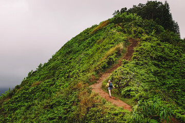 Woman hiking up the top of the hill