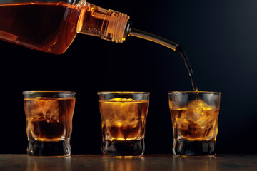 Poster - Whiskey is poured into glasses with ice.