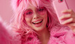 © anatoliycherkas - Stylish woman with pink hair taking selfie in pink studio background. Portrait of glamour woman taking selfie indoors