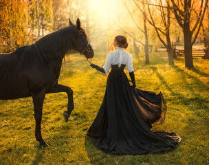 fantasy woman walking with black horse. Happy adult girl turned away Beauty lady back rear view. love care pet. Summer nature forest sun light. long dress old style fly wind. art photo real person