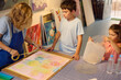 © Taras Grebinets - Children enjoying art class with teacher, creating colorful paintings in workshop