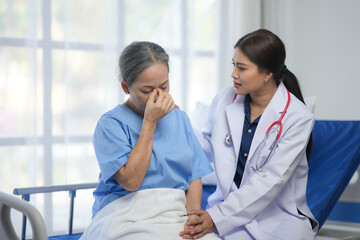 A healthcare professional comforts a distressed elderly patient, offering emotional support in a hospital setting.