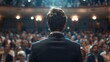 © horizon - A man in suit standing on stage, looking at the audience with confidence and inspiration while giving an drive them to success speech.