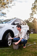 © Austockphoto - Smiling teen doing chores – washing wheels of family car