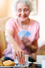 Sticker - Elderly woman, table and hand with playing cards in retirement home for fun, activity and strategy. Happy, senior person and relax with snack in game for competition, contest and problem solving