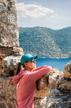 Tourist woman looking out through the ancient ruins in Antalya Province, Turkey