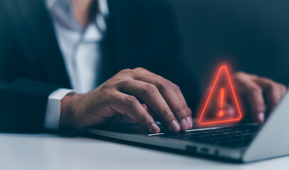 a businessman developer using laptop computer with triangle caution warning sign for notification er