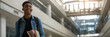 © MarGa - Smiling african male student holding books in a modern college hallway, symbolizing academic ambition and the back-to-school season