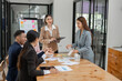 © aekachai - Asian business group discussing graph work at the office..