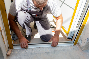 Professional carpenters installing an entrance door in a new apartment. Door installation worker replaced the old one with a new one