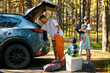 © ronstik - family with kids remove the camping supplies from car trunk at forest. summer vacation, road trip