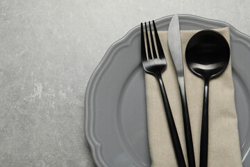 Wall Mural - Stylish cutlery, napkin and plate on grey table, top view. Space for text