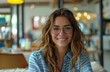 © ArtCookStudio - Young Woman Wearing Glasses and Striped Shirt Smiles in Office Setting