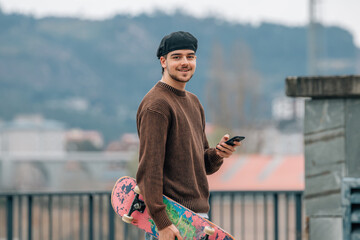 Poster - young man on the street with mobile phone and skateboard