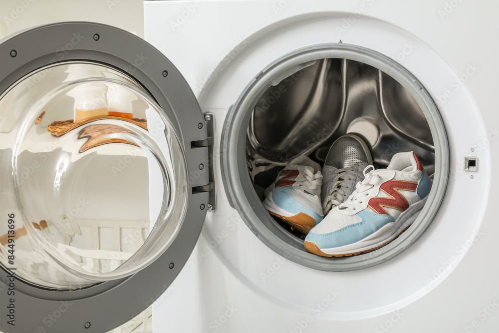 Open washing machine with sneakers, closeup