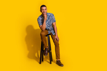 Canvas Print - Full length photo of dreamy positive guy dressed print shirt sitting stool empty space isolated yellow color background