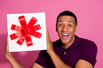 Canvas Print - Photo portrait of attractive young man hold giftbox excited dressed stylish violet clothes isolated on pink color background