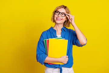 Wall Mural - Portrait of pretty young lady look empty space wear blue shirt isolated on yellow color background