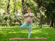 © Михаил Решетников - Pregnant caucasian woman doing yoga in the park. Tree pose.