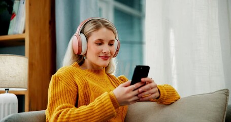 Canvas Print - Happy woman, typing and phone with headphones on sofa for online streaming, browsing or connection at home. Female person with headset, smile or scrolling on mobile smartphone for music list or app