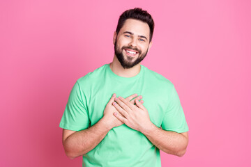 Sticker - Photo of appreciative thankful nice guy with stylish beard dressed green t-shirt hold arms on chest isolated on pink color background