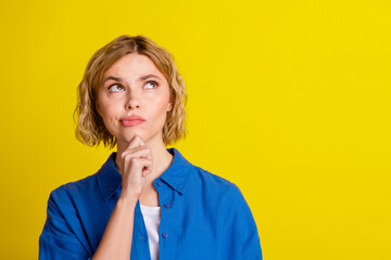 Wall Mural - Portrait of pretty young lady look interested empty space wear blue shirt isolated on yellow color background