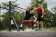 © qunica.com - Fitness-focused man and woman using outdoor gym equipment for a strenuous workout in a lush park setting. Both display intent and concentration.